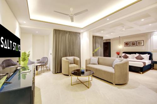 a living room with a couch and a bed at Saltstayz Amara - Near MG Road and Sector 29 in Gurgaon
