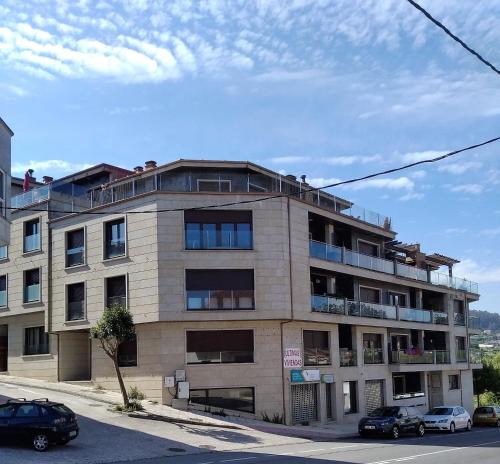 un condominio con auto parcheggiate di fronte di Vacaciones en Costa Morrazo, playas y restaurantes a Pontevedra