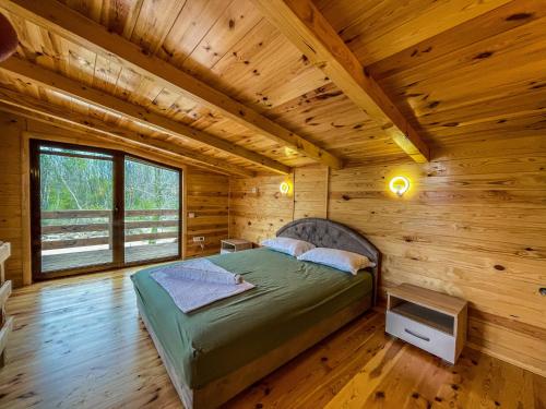 a bedroom in a log cabin with a bed at Mini Tri in Ulcinj