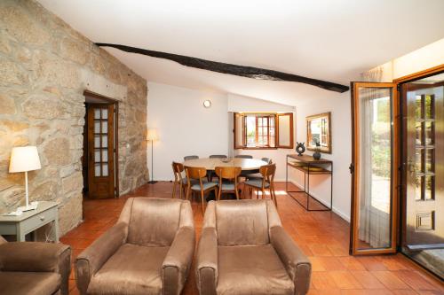 a living room with a table and chairs at Casa da Eira by Quantique in Amares