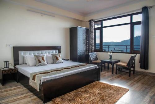 sypialnia z dużym łóżkiem i dużym oknem w obiekcie Goroomgo शिमला Nature Ville - A Luxury Collection w mieście Shimla
