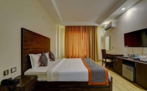 a hotel room with a large bed and a desk at Janardana Resorts in Vrindāvan