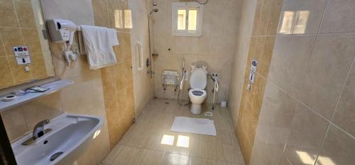 a bathroom with a white toilet and a sink at الرموز الصادقة للشقق المخدومة Apartments alrumuz alsadiqah in Jeddah