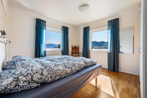 a bedroom with a bed and two windows at Villa Ocean View in Askøy