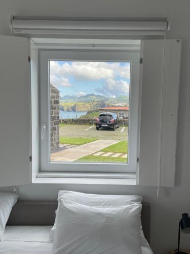 ein Fenster in einem Schlafzimmer mit einem draußen geparkt in der Unterkunft João de Oliveira casas de campo in Santo António