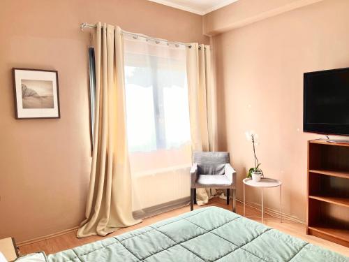 a bedroom with a bed and a window at Crystal Clear - 2 separate bedrooms and PARKING in Komotini