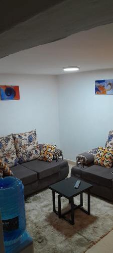 a living room with two couches and a coffee table at Derrian Homes in Eldoret