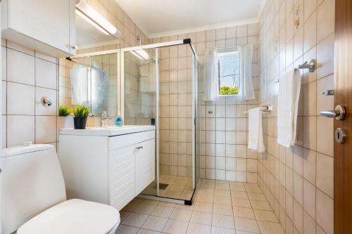 a bathroom with a shower and a toilet and a sink at Villa Ocean View in Askøy