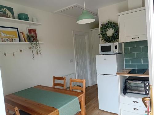 a kitchen with a table and a white refrigerator at Galway Riverside Retreat in Galway