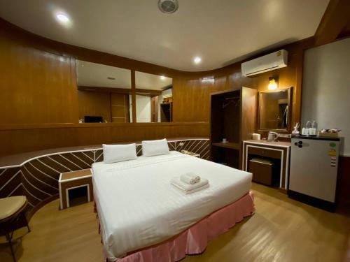 a bedroom with a large bed and a kitchen at โรงแรม เพนท์เฮ้าส์ รีสอร์ท เบตง in Betong