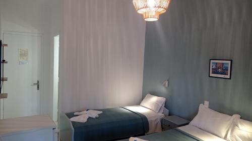 a small room with two beds and a chandelier at Acheron rooms in Preveza