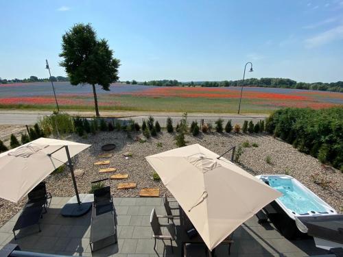 a patio with two umbrellas and a swimming pool at Auszeit Oase Heidi in Göhren-Lebbin