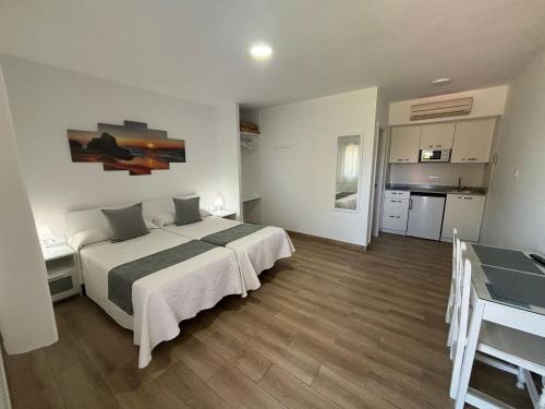 a bedroom with a large bed and a kitchen at El Levante in Tarifa