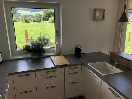 a kitchen with a sink and a large window at Haus Johanna in Westendorf