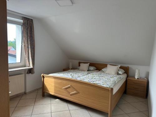 a bedroom with a wooden bed with a window at Aminas Ferienwohnung Bad Gandersheim 30/2 in Bad Gandersheim