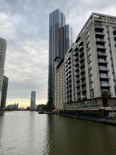 ロンドンにあるCanary Wharfの水の隣に高層建築物がある都市