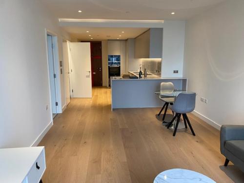 eine Küche und ein Wohnzimmer mit einem Tisch und Stühlen in der Unterkunft Canary Wharf in London