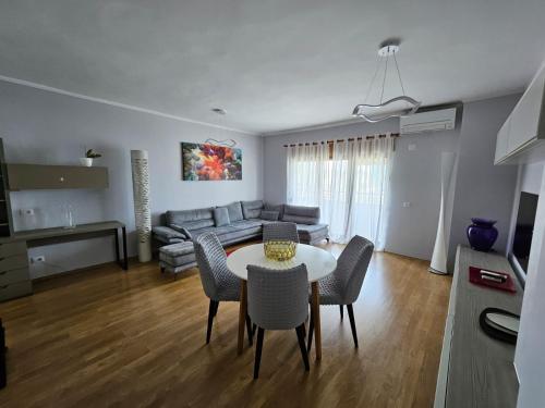 een woonkamer met een tafel en stoelen en een bank bij SKY DWELLING TIRANA in Tirana