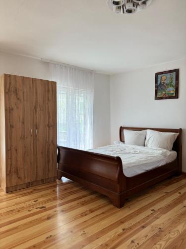 a bedroom with a large bed and a wooden cabinet at Прикарпаття in Kosiv