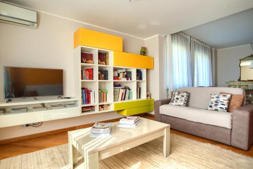 a living room with a couch and a tv at Villa Giovanna con terrazza panoramica, Jacuzzi e sauna in Loano