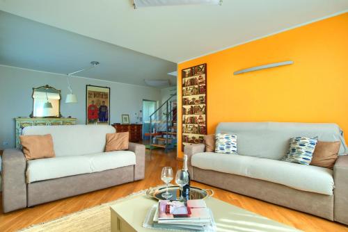a living room with two couches and an orange wall at Villa Giovanna con terrazza panoramica, Jacuzzi e sauna in Loano