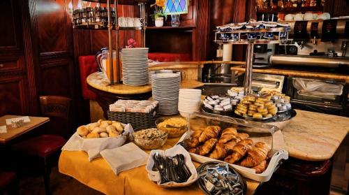 una cucina con tavolo pieno di pane e dolci di Hotel Lux a Venezia