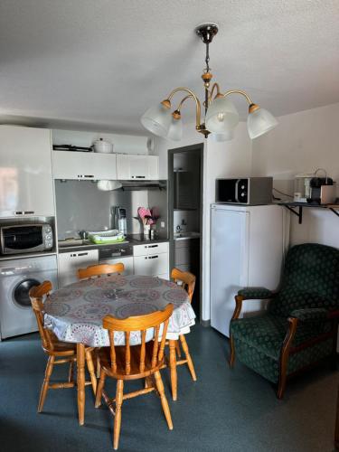 une cuisine avec une table et des chaises ainsi qu'une salle à manger dans l'établissement Appartement Le Barcarès vue mer, au Barcarès