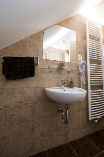 a bathroom with a sink and a mirror at Penzion Admirál in Třeboň