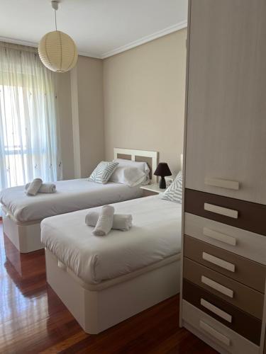 a bedroom with two beds and a dresser at Acogedor apartamento en Gernika in Guernica y Luno