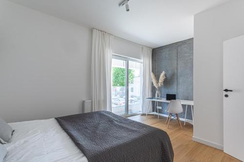 una camera con letto, scrivania e finestra di S35 Apartments Gdynia Orłowo a Gdynia