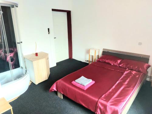 a bedroom with a red bed with a red blanket at Gasthof Oberschmiede in Auf der Wiese