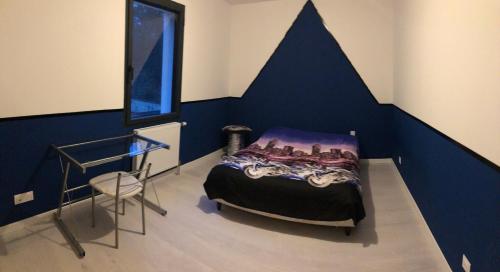 une chambre avec un lit avec un mur bleu dans l'établissement 4 chambres - 8 personnes, à Changé