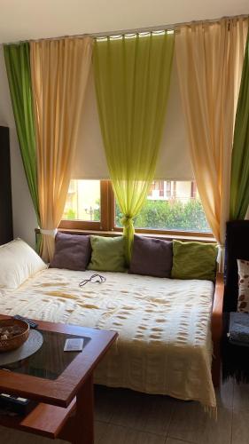 a bedroom with a large bed with green curtains at Siana 1 Apartment in Sveti Vlas