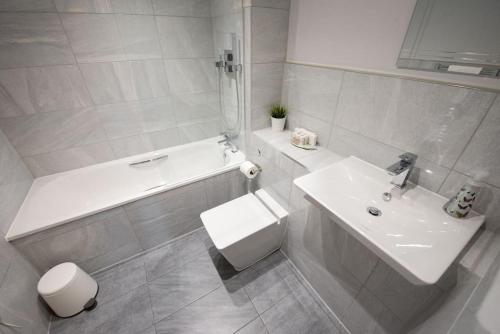 a bathroom with a sink and a tub and a toilet at Modern,Bright and spacious 2 bed in Brentwood