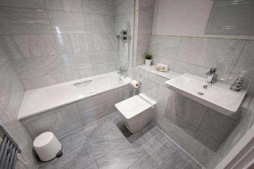 a bathroom with a sink and a tub and a toilet at Modern,Bright and spacious 2 bed in Brentwood