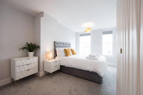 een witte slaapkamer met een bed en een raam bij Modern,Bright and spacious 2 bed in Brentwood