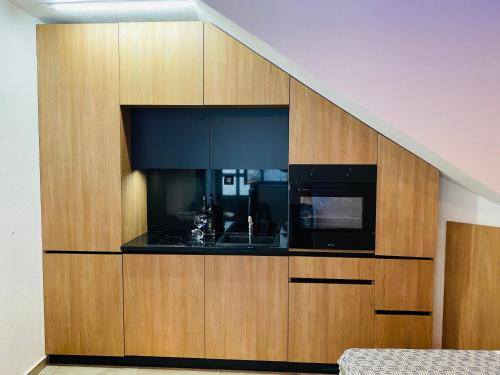 a large wooden cabinet with a microwave and a kitchen at 7A Seven A in Crikvenica