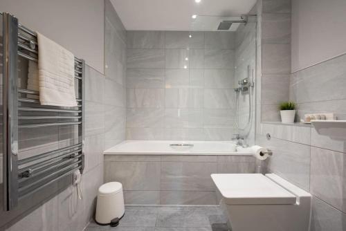een witte badkamer met een bad en een wastafel bij Modern,Bright and spacious 2 bed in Brentwood