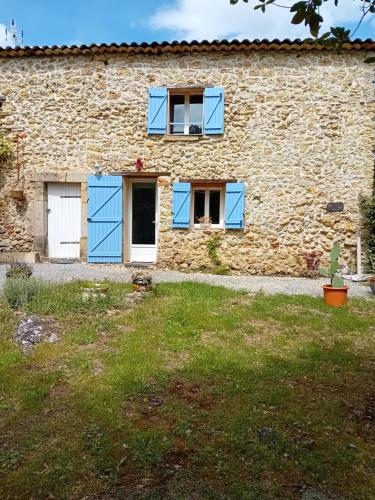 una vecchia casa in pietra con finestre blu e un cortile di la bergerie a Tourtour