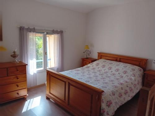 um quarto com uma cama, uma cómoda e uma janela em la bergerie em Tourtour