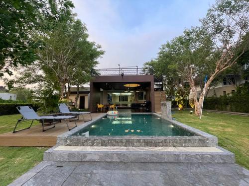 a swimming pool in the backyard of a house at Momento Poolvilla Khaoyai in Ban Khanong Phra Nua