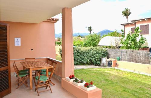 eine Terrasse mit Tisch und Stühlen und ein Garten in der Unterkunft ISS Travel, Gli Asfodeli - Large apartments with private terrace in San Teodoro