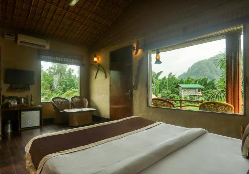 1 dormitorio con cama grande y ventana grande en Tashree Kabeela Riverside Resort, en Marchula