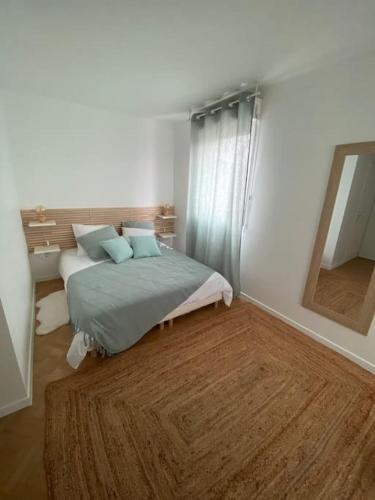 une chambre avec un lit et un miroir dans l'établissement La Terrasse Parisienne - Vue Tour Eiffel, à Vitry-sur-Seine