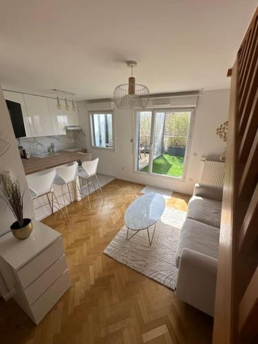 un salon avec un canapé et une table dans l'établissement La Terrasse Parisienne - Vue Tour Eiffel, à Vitry-sur-Seine