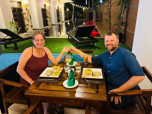 um homem e uma mulher sentados à mesa com comida em Mama’s Boutique Beach Hotel em Negombo