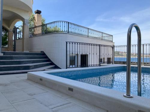 a swimming pool in a house with stairs and a building at Villa Ella in Sevid