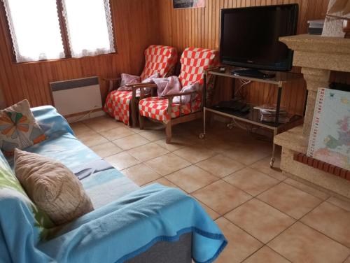 un salon avec deux chaises et une télévision dans l'établissement Maison Damgan 5 min à pied de la grande plage, à Damgan