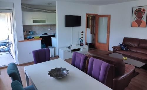 a living room with a table and purple chairs at A l e k a in Radovići