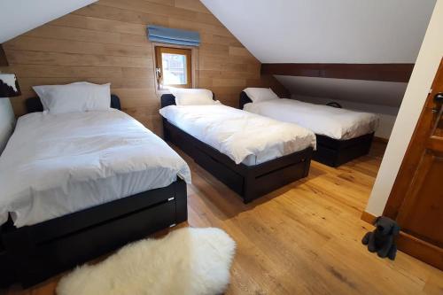 deux lits dans une chambre avec parquet dans l'établissement Duplex centre ville de Megève MEG1384HTP, à Megève